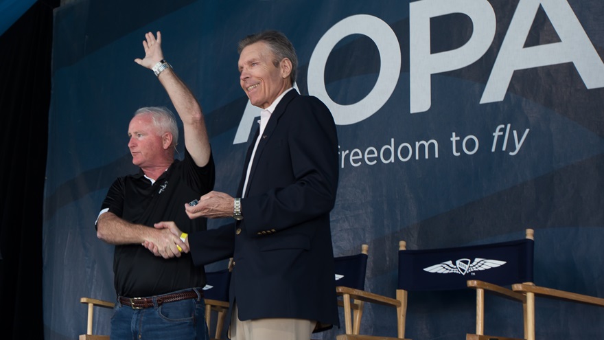 AOPA President and CEO Mark Baker, left, presents a 50-year AOPA membership pin to Michael Magnell, who also received an FAA Wright Brothers Master Pilot Award at EAA AirVenture July 28. Jim Moore photo.