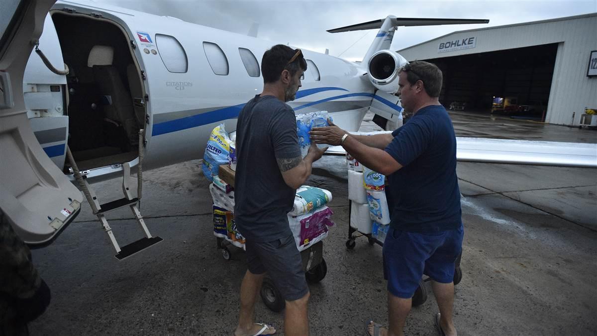 Hurricane Irma victims Steve Hookstra and Mike Keaton help unload supplies and medicine from an aircraft at the St. Croix, U.S. Virgin Islands, general aviation ramp Sept. 14. Hookstra and Keaton had attended a friend's wedding at nearby St. John before the powerful storm hit. Photo by David Tulis.