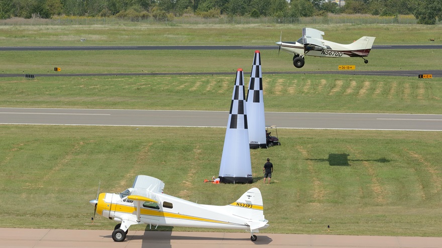 A Maule approaches the 50-foot cones a little low during the Texas STOL Roundup flight demonstration Saturday afternoon at AOPA's 2017 Norman Fly-In, while a de Havilland Beaver waits to take off. Photo by Mike Collins.