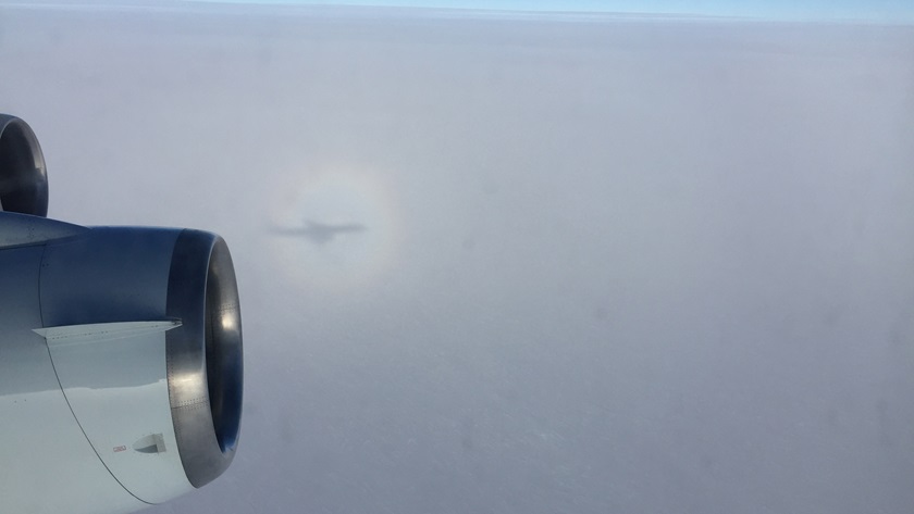 An optical phenomenon called the glory around the shadow of the DC-8 caused by the backwards emission of sunlight due to resonance effects with the thin haze layer over the polar plateau, as seen during IceBridge's mission "Pole Hole 88 West" on Oct. 26, 2016. Photo courtesy of NASA/Nathan Kurtz.