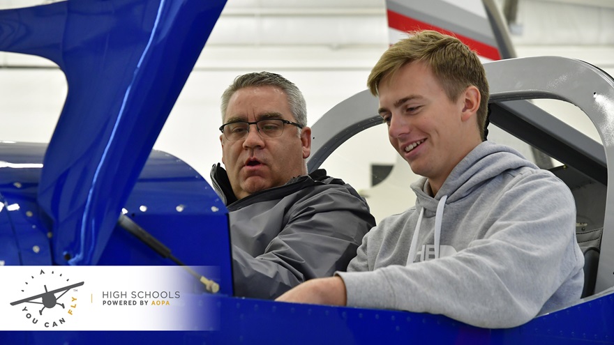 Phillip Campbell familiarizes McKinney High School student Bryan Soltys-Niemann with a Van's Aircraft RV-12 cockpit during an aviation class at McKinney National Airport in McKinney, Texas, Nov. 8. McKinney High School is one of 29 high schools field testing the ninth-grade AOPA High School Aviation STEM curriculum developed by AOPA’s You Can Fly High School Initiative which supports aviation programs and career development for teens. Photo by David Tulis.