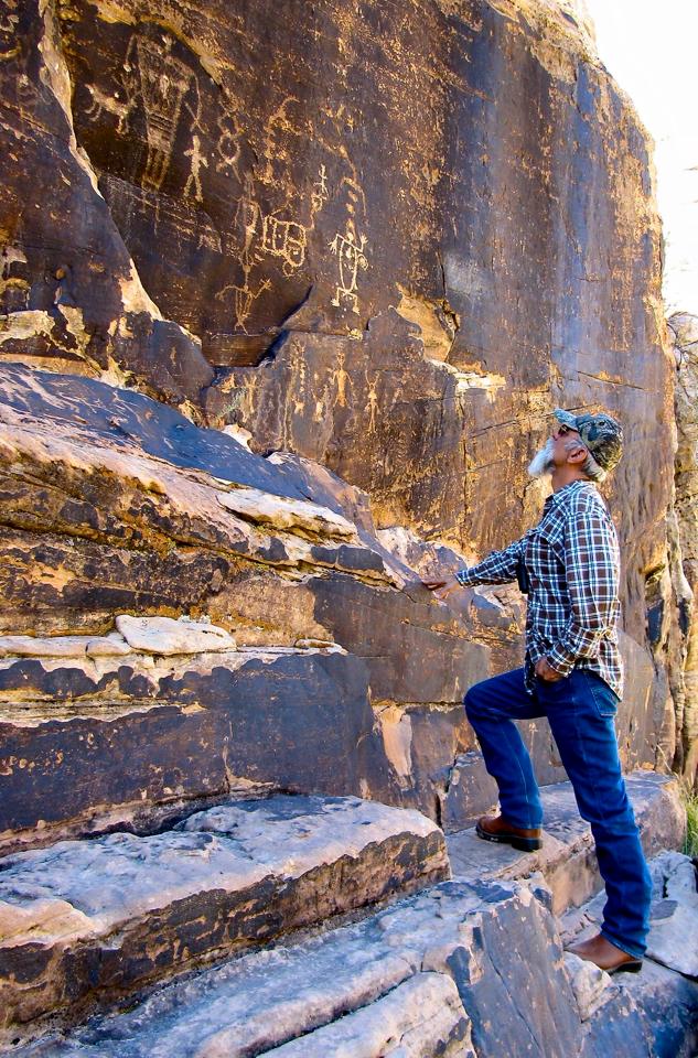 A visitor admires Native American petroglyphs at Rock Art Ranch. Some of the petroglyphs discovered here are highly unusual. Photo courtesy Rock Art Ranch.