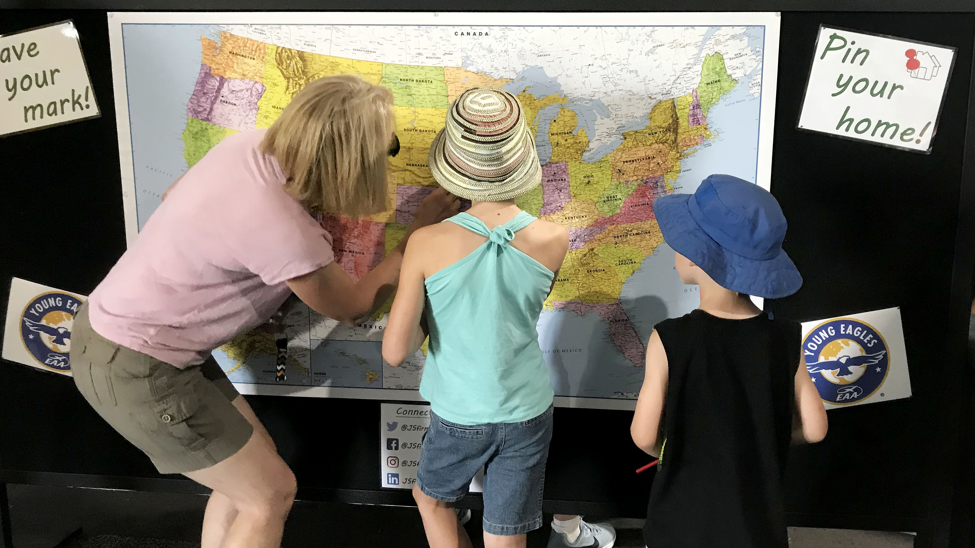 Visitors use pins to mark their hometowns at the JS Firm booth. Photo by Jill Tallman.