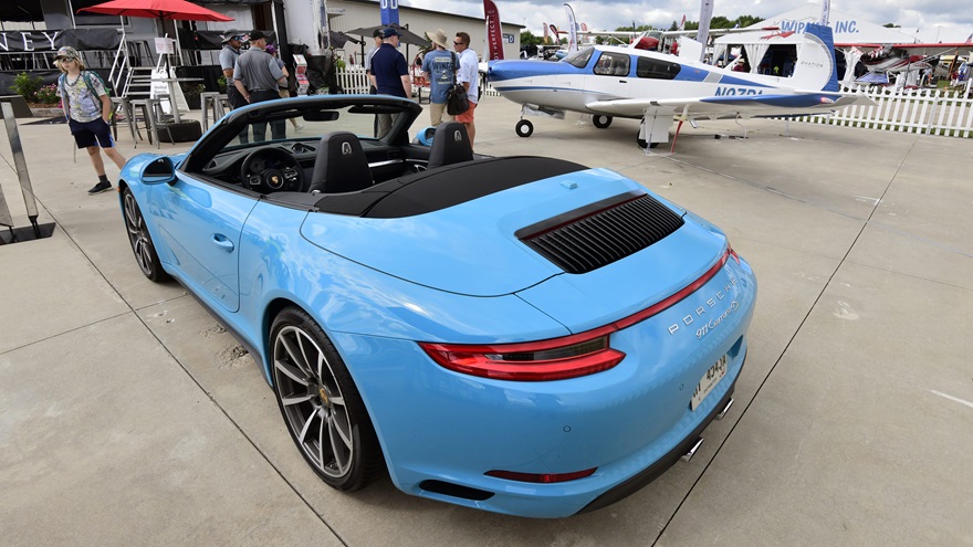 A new Porsche 911 Carrera is displayed with a new Mooney at EAA AirVenture 2018. Both Porsche North America and Mooney are celebrating their 70th anniversaries this year. Photo by Mike Collins.