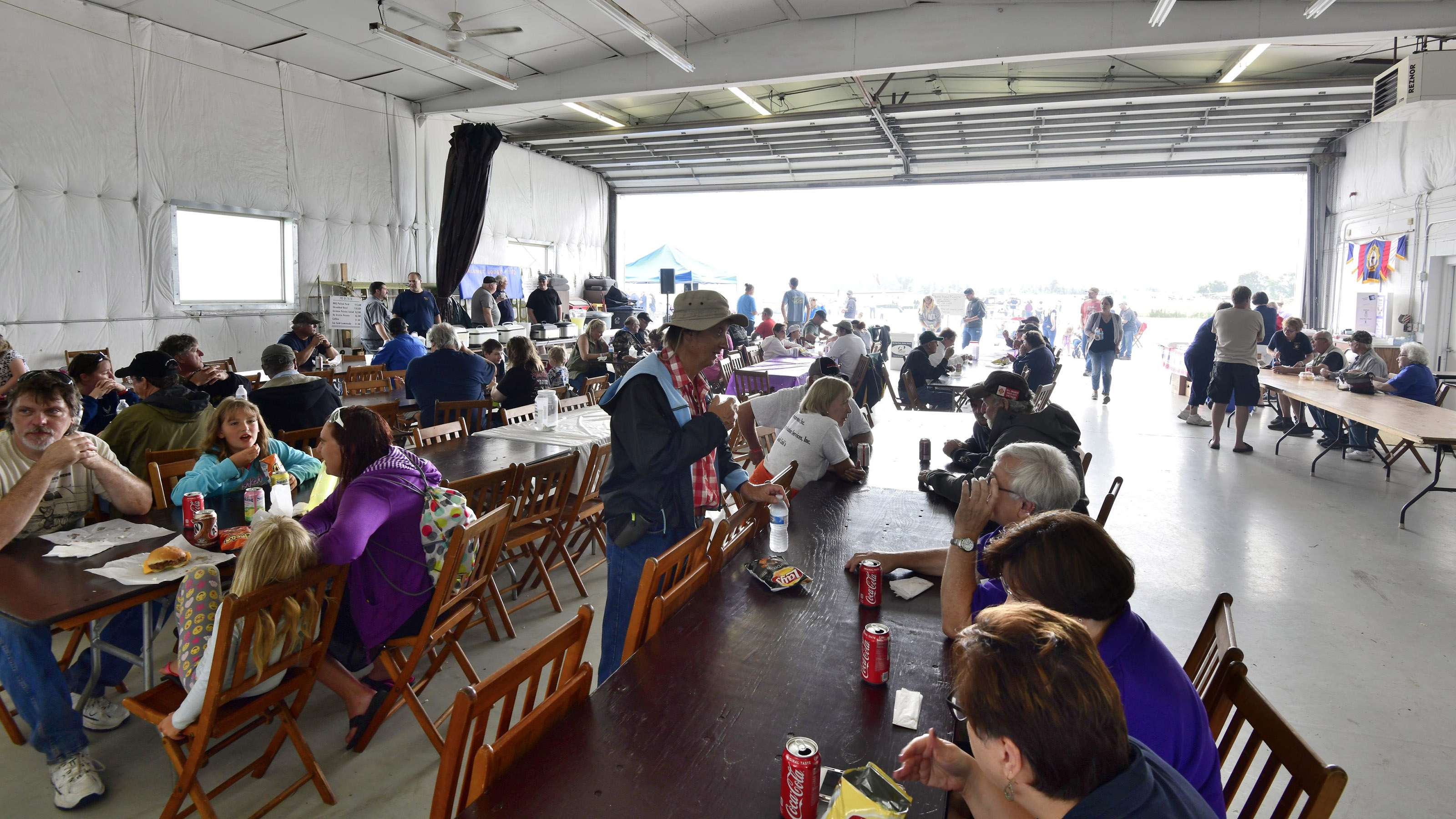 New Holstein Airport Day is held on the Saturday of the Super Cub Fly-In. Local civic organizations serve food in the airport's maintenance hangar, and many members of the community come out to see the airplanes--and eat. Photo by Mike Collins.