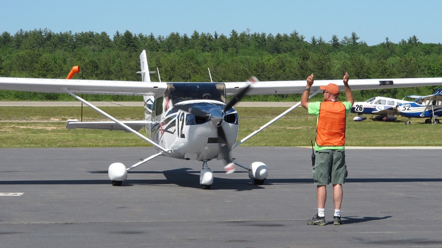 Lin Caywood and Bev Weintraub are marshaled to parking  after landing at Eastern Slope Regional Airport in Fryeburg, Maine, at the end of the Air Race Classic June 22. Photo by Dan Namowitz.
