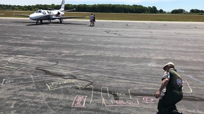 AOPA Airport Support Network volunteer Graeme Smith traced the outline of Newport State Airport’s runways in chalk to give visitors a pilot's perspective. Photo by Sean Collins.