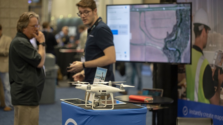 DroneDeploy Content Marketing Manager Devon Tackels, center, talks to a visitor about the company's new offerings at AUVSI Xponential in Denver May 2. Photo by Jim Moore.