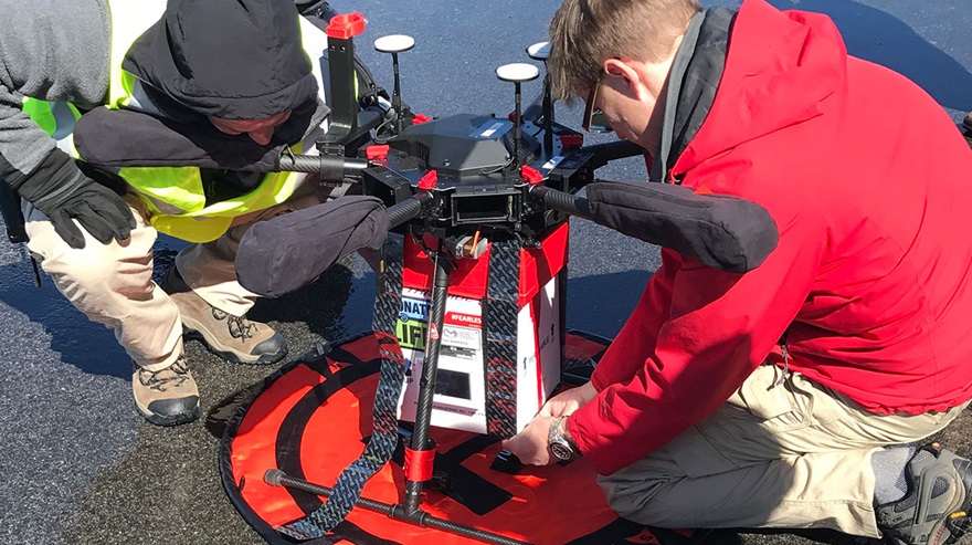 University of Maryland UAS Test Site pilot Ryan Henderson, left, and project engineer Jacob Moschler prepare the payload for an April 2018 test flight. Photo courtesy of Dr. Joseph Scalea. 