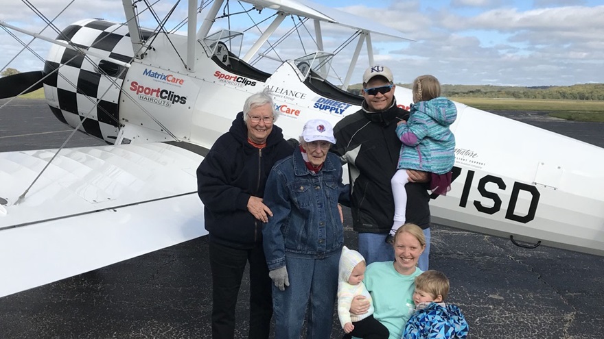 Norma Evans, age 104, poses with three generations of her family beside an Ageless Aviation Dreams Stearman. She took her second flight in the open-cockpit biplane. Photo courtesy of the Ageless Aviation Dreams Foundation.