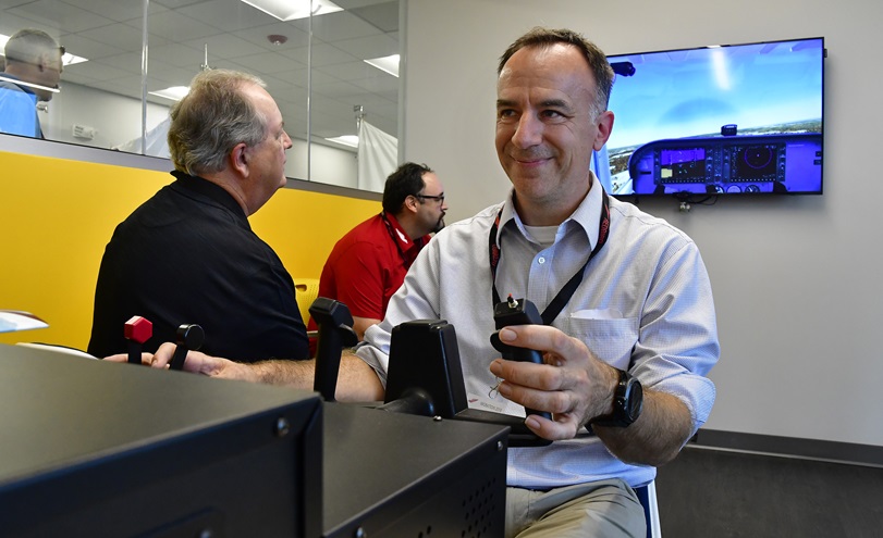 AOPA 2018 Flight Training Experience Award-winning best CFI Mike Biewenga of Blue Skies Flying Service near Chicago, tries his hand at 'blind flying' a Redbird Jay flight simulator with coaching from his team during Redbird Migration at the AOPA You Can Fly Learning Center campus in Frederick, Maryland, Oct. 10, 2018. Photo by David Tulis.