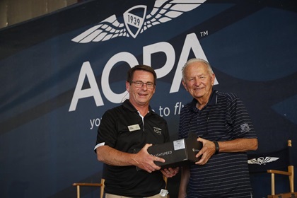 AOPA Senior Vice President of Media, Communications, and Outreach Tom Haines congratulates Bill Blake for flying the farthest to the AOPA Fly-In. Blake won a Lightspeed headset and a one-year subscription to Garmin Pilot. Photo by Chris Rose.