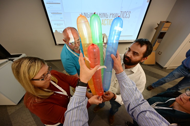 High school educators Debbie Judd, Royce Turner, Peter Reyes, and Megan Dutto fashion a four-balloon rocket to test a payload and thrust during an AOPA ninth grade curriculum workshop. Photo by David Tulis.