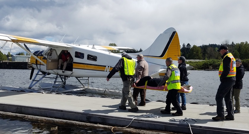 Seattle volunteers stage a simulated patient near a Kenmore Air Harbor de Havilland Otter seaplane during an earthquake disaster drill that relied on land-based and float-equipped general aviation aircraft to ferry supplies and transport patients. Photo courtesy of Tara Terry.