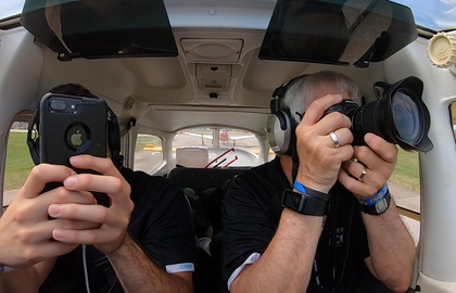 AOPA staffers Kevin Cortes and David Tulis spot military jets and airshow performer Matt Younkin from a taxiway before departing Wittman Regional Airport after EAA AirVenture. Photo by David Tulis.