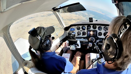 Kim Purcell, left, banks her Bonanza as she and husband/co-pilot Rob Kirkpatrick look for a checkpoint during the 2017 Hayward Air Rally. Some checkpoints are airports, but pilots must answer detailed questions and photograph the checkpoints to show they found the correct locations. Photo by Mike Collins.