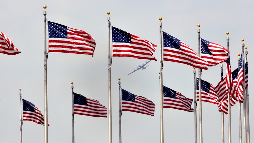 Framed by flags surrounding the base of the Washington Monument, the Commemorative Air Force's B-29 "Fifi" banks during the Arsenal of Democracy: World War II Victory Capitol Flyover on May 8, 2015. A second Arsenal of Democracy Flyover will take place Friday, May 8, 2020. Photo by Mike Collins.