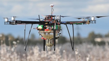 One of Dropcopter’s hexacopters distributes pollen with precision over almond trees. Photo courtesy of Dropcopter.