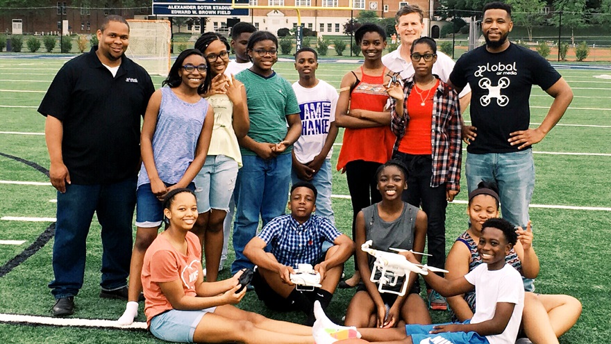 Global Air Media co-founders Austin Brown, far left, and Eno Umoh, far right, pose with a drone camp class at the very high school that they attended. Photo courtesy of Global Air Media.