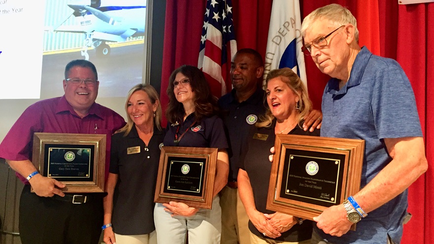 FAA General Aviation Awards Program staff members join national winners on the stage at EAA AirVenture. Left to right, winners holding plaques are Certificated Flight Instructor of the Year Gary Reeves; FAASTeam Representative of the Year Karen Kalishek; and Aviation Maintenance Technician of the Year Dave Monti. Photo by Adrian Eichhorn.