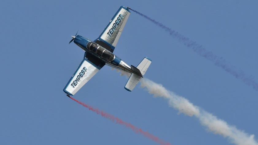 The polished Beech T-34 Mentor of veteran airshow performer Julie Clark rolls above EAA AirVenture. Clark is retiring at the end of this season. Photo by Mike Collins.