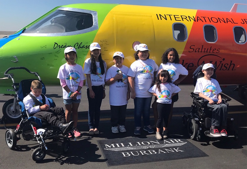 With some of their signatures on the fuselage behind them, Make-A-Wish recipients gather near a rainbow-colored 1982 Learjet 35A operated by International Jet Aviation. Photo courtesy of International Jet Aviation.