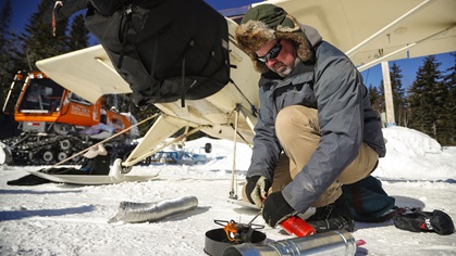 A camp stove provides the heat, and ducts direct it into the engine compartment on a subzero morning. Preheating the engines is an essential part of preflight preparation for skiplane flying.