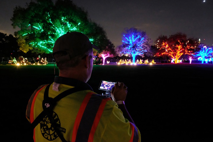 Austin American-Statesman staff photographer Jay Janner makes adjustments to the photos and video his Phantom 4 Pro+ drone is capturing as it surveys the scene of the Trail of LIghts in ZIlker Park on December 3, 2017. This is looking at the portion of the Trail just above Lou Neff Point, and the navigation lights of the drone can be seen at the far upper-right of the photo. Zach Ryall photo.