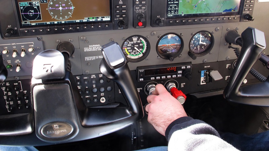 A flight instructor guards the throttle during a slow-flight demonstration. Photo by Dan Namowitz.