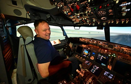 High school aviation teacher and retired U.S. Marine helicopter pilot Kevin Moss smiles after landing a Boeing 737 simulator at the United Airlines training facility in Denver. Photo by David Tulis.