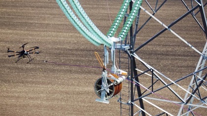 After hauling the lead line to the next tower, there is still a tricky bit of flying left to do, lowering the sock onto the orange guide and tugging it into place. Photo courtesy of SkySkopes.