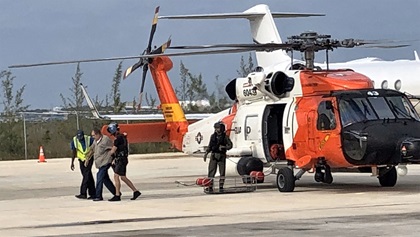 A pilot who had to ditch his Cessna 210 north of Eleuthera, Bahamas, on December 23, is helped from the U.S. Coast Guard MH-60 Jayhawk that rescued him after it landed at Nassau International Airport. Photo courtesy of the U.S. Coast Guard.