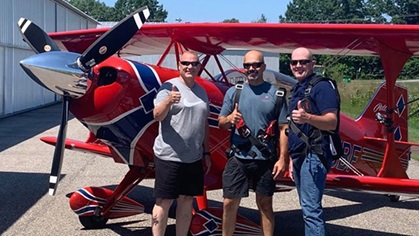 New Hampshire pilot Brian Beaudry, center, began the Props for Cops outreach to honor law enforcement personnel with flights in a Pitts S–2C aerobatic biplane. Photo courtesy of Brian Beaudry, Props for Cops.
