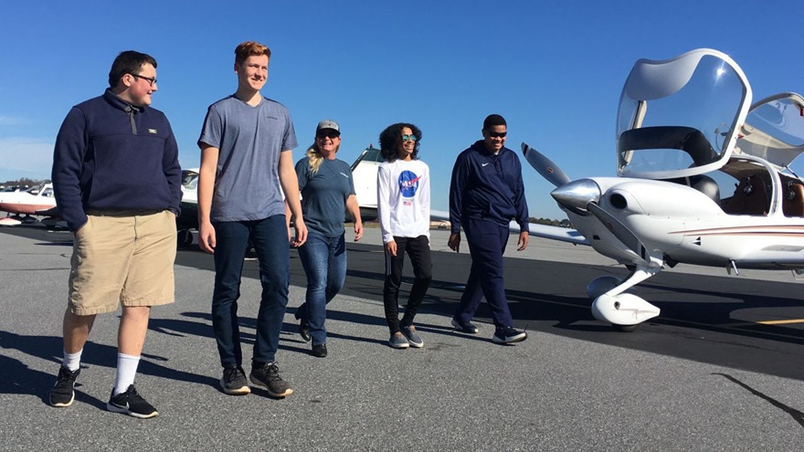 Students from Greenville Technical Charter High School walk to the flight line to see the aircraft in which they will be flying. Photo courtesy of STEM Flights.