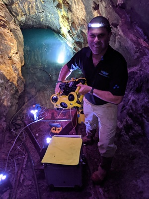 Nir Pe’er, CEO and founder of Inspired Intelligence, holds the M2 underwater drone after a scan was completed in one of the water-filled mine tunnels. Photo courtesy of Inspired Intelligence.