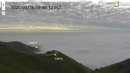 A wildfire surveillance camera captured this image near the crash site, about a minute before the helicopter struck the ground below the cloud layer. Photo courtesy of the NTSB.