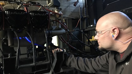 A technician uses a handheld black light to inspect a Continental engine for oil leaks before shipping it to a customer. Photo courtesy of Jeff Simon.