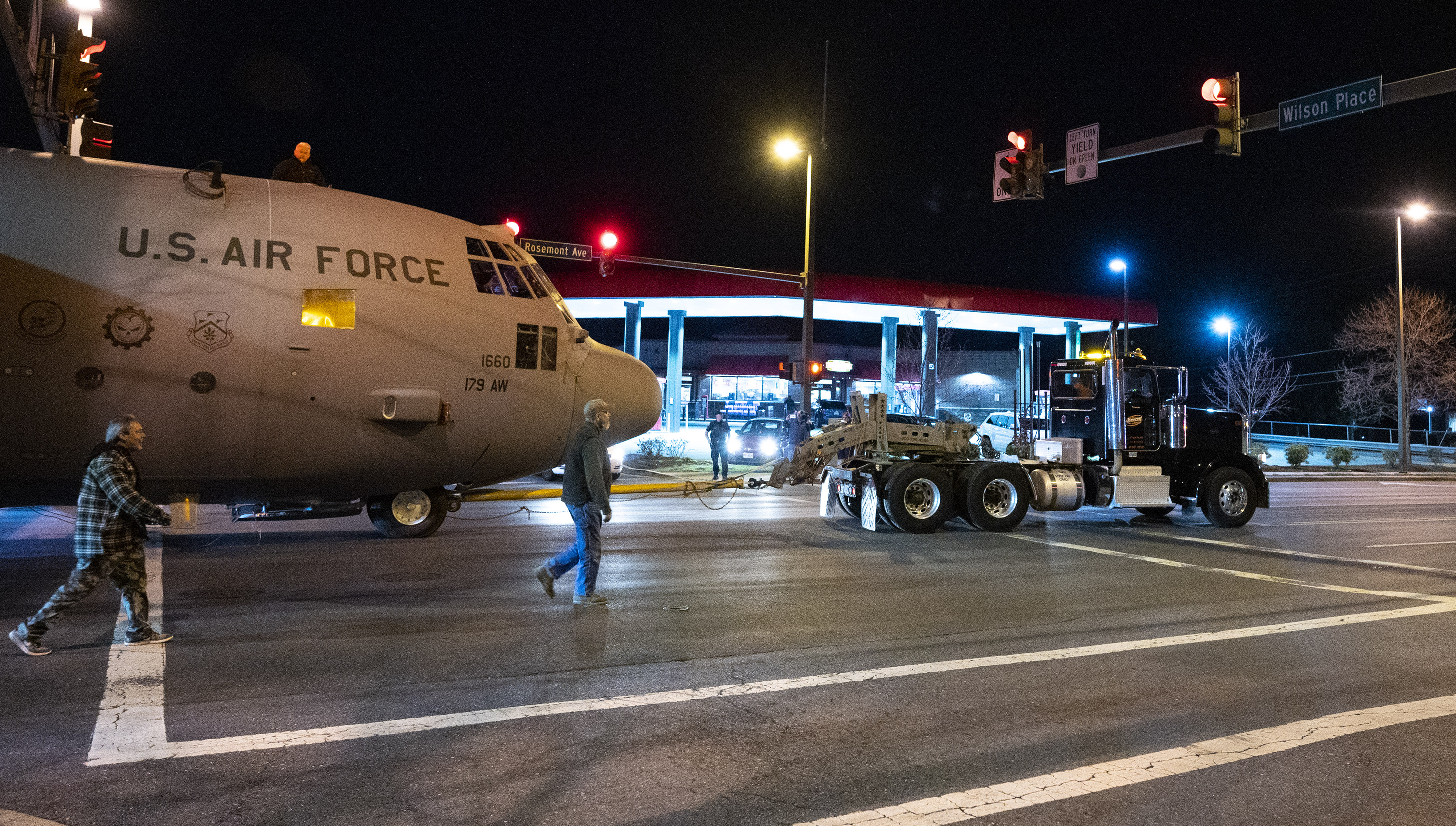 A U.S. Air Force Lockheed C-130H Hercules military aircraft previously based in Ohio is moved past a Rosemont Avenue gas station to Fort Detrick during the retired aircraft’s final journey. Photo by David Tulis.