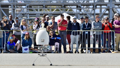 Attendees watch a scale model of the Texas A&M Harmony team's Aria personal helicopter power up February 29 at the GoFly Prize Final Fly Off. Winds precluded any flying. Photo by Mike Collins.