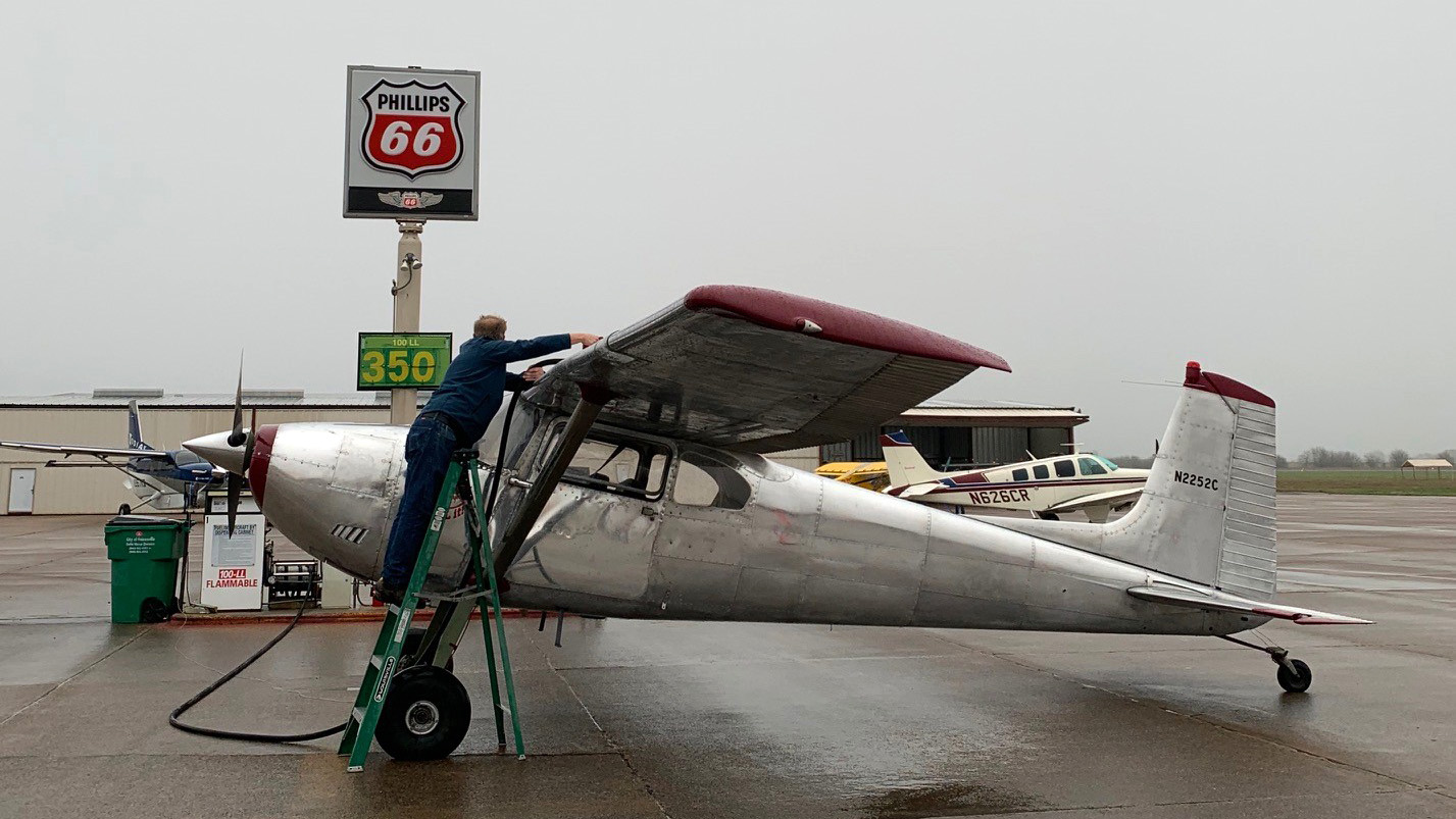 Don Mickey refuels his Cessna 180 under a dark sky. Photo by Alicia Herron.
