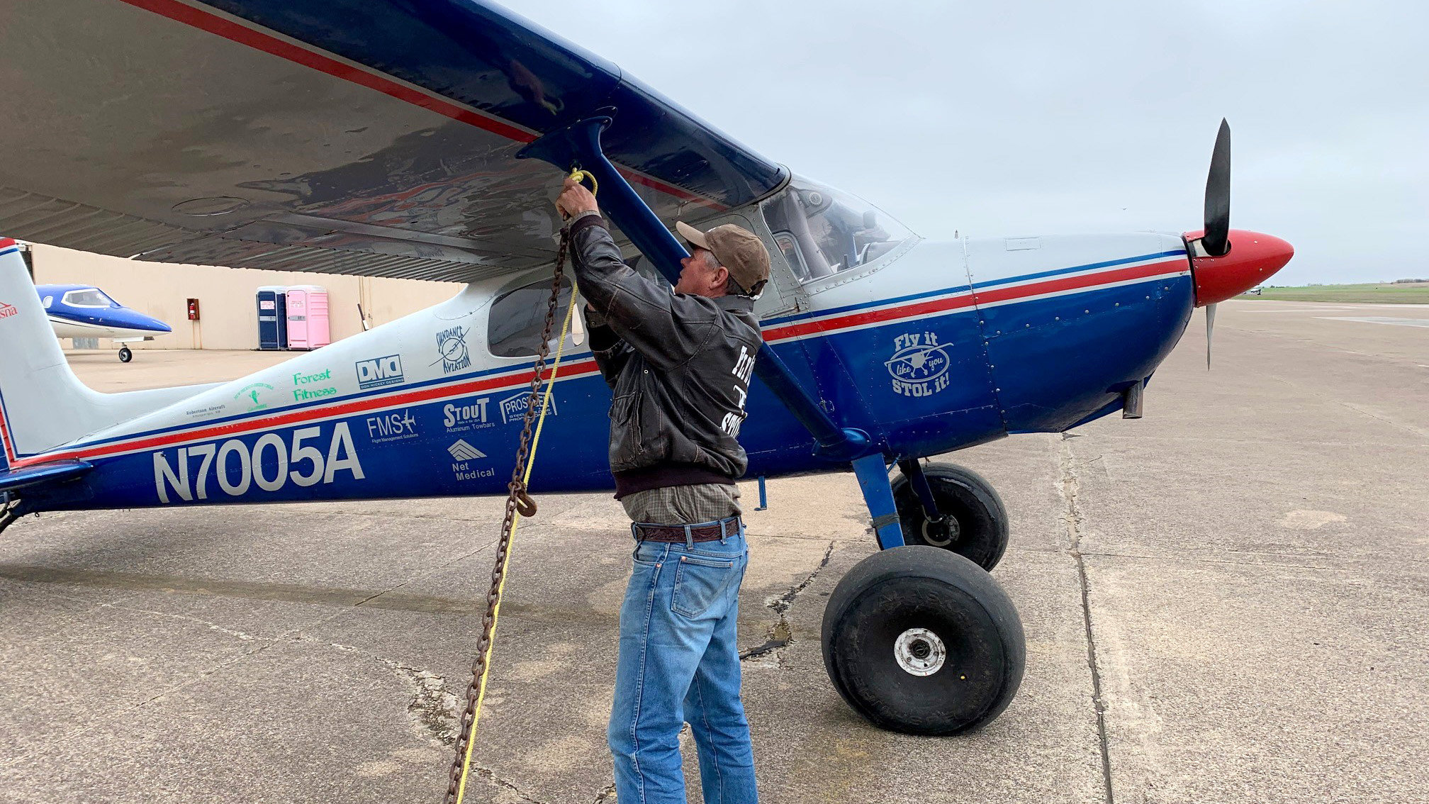 Clayton Stansell ties down his taildragger 172, which is covered in sponsor stickers for his trip to Lonestar STOL. The most charming? New Mexico Green Chile. Photo by Alicia Herron.