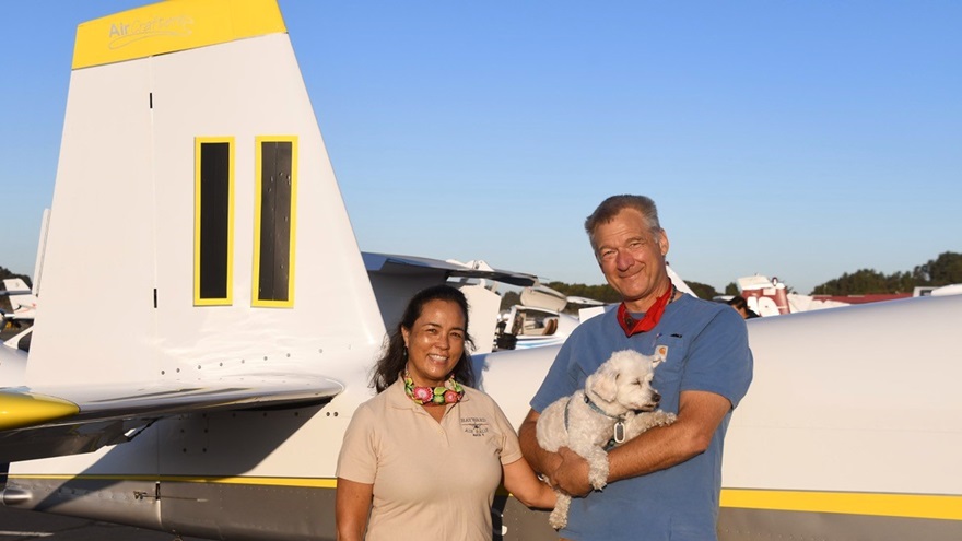 Mitzi Saylor and her husband and co-pilot, Dave Saylor (holding Millie, their Maltese mix), stand beside the Van's Aircraft RV-10 in which they won the 2020 Hayward Air Rally. Photo by Carl La Rue.