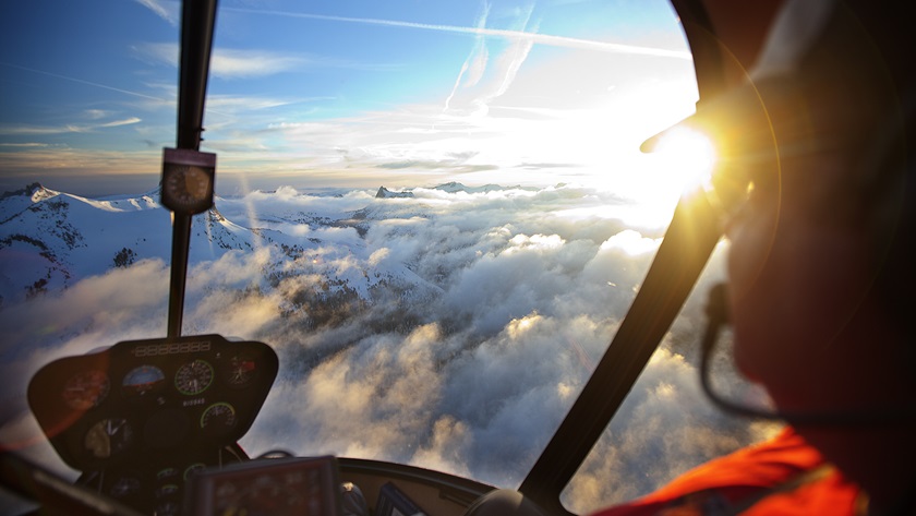 The sun peeks over snowcapped mountains in the Mammoth Lakes area. Photo courtesy of SkyTime Helicopter Air Tours.