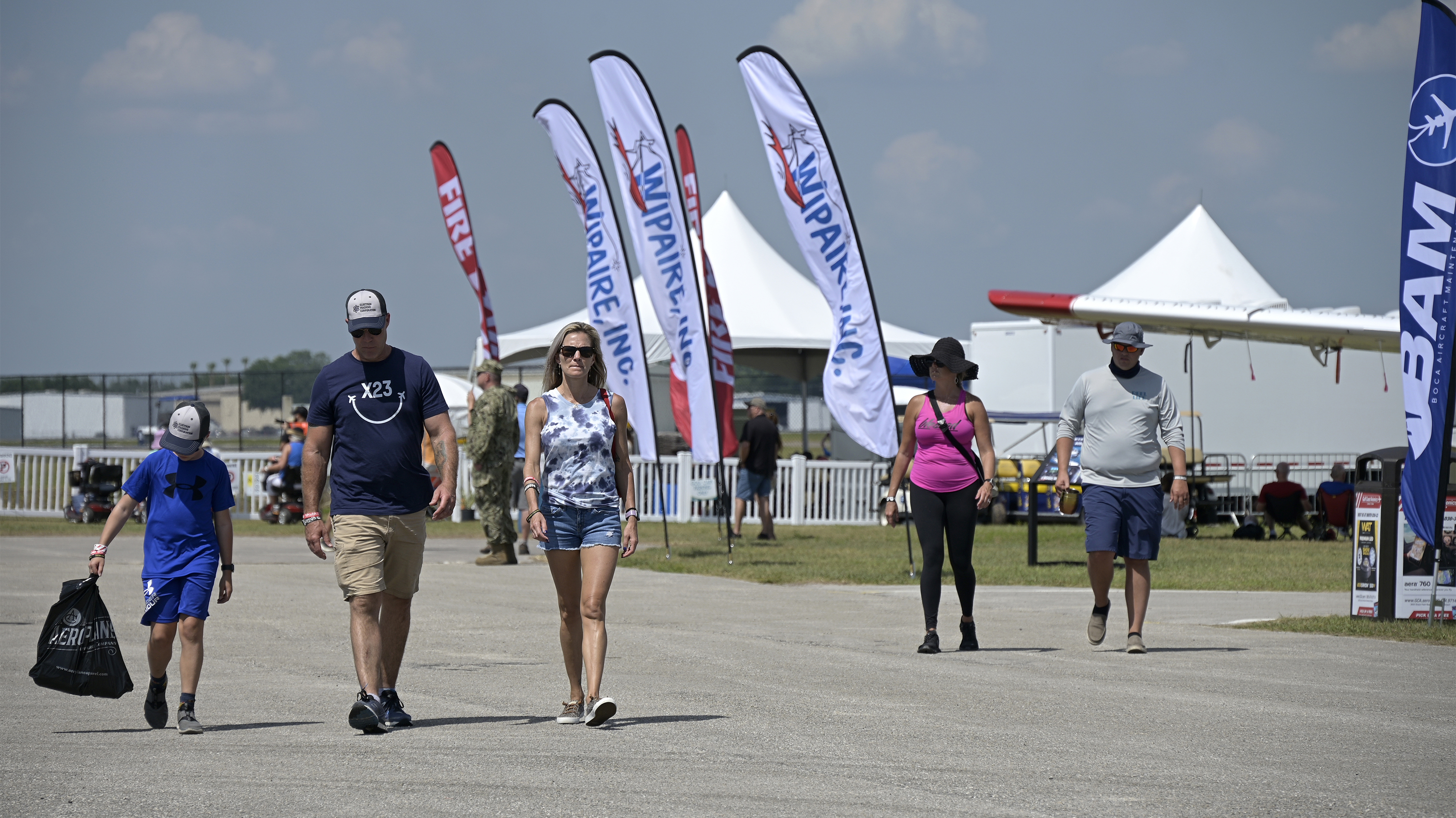 Sun 'n Fun Aerospace Expo attendees stroll past the static display area on April 14. Photo by Phelan M. Ebenhack.