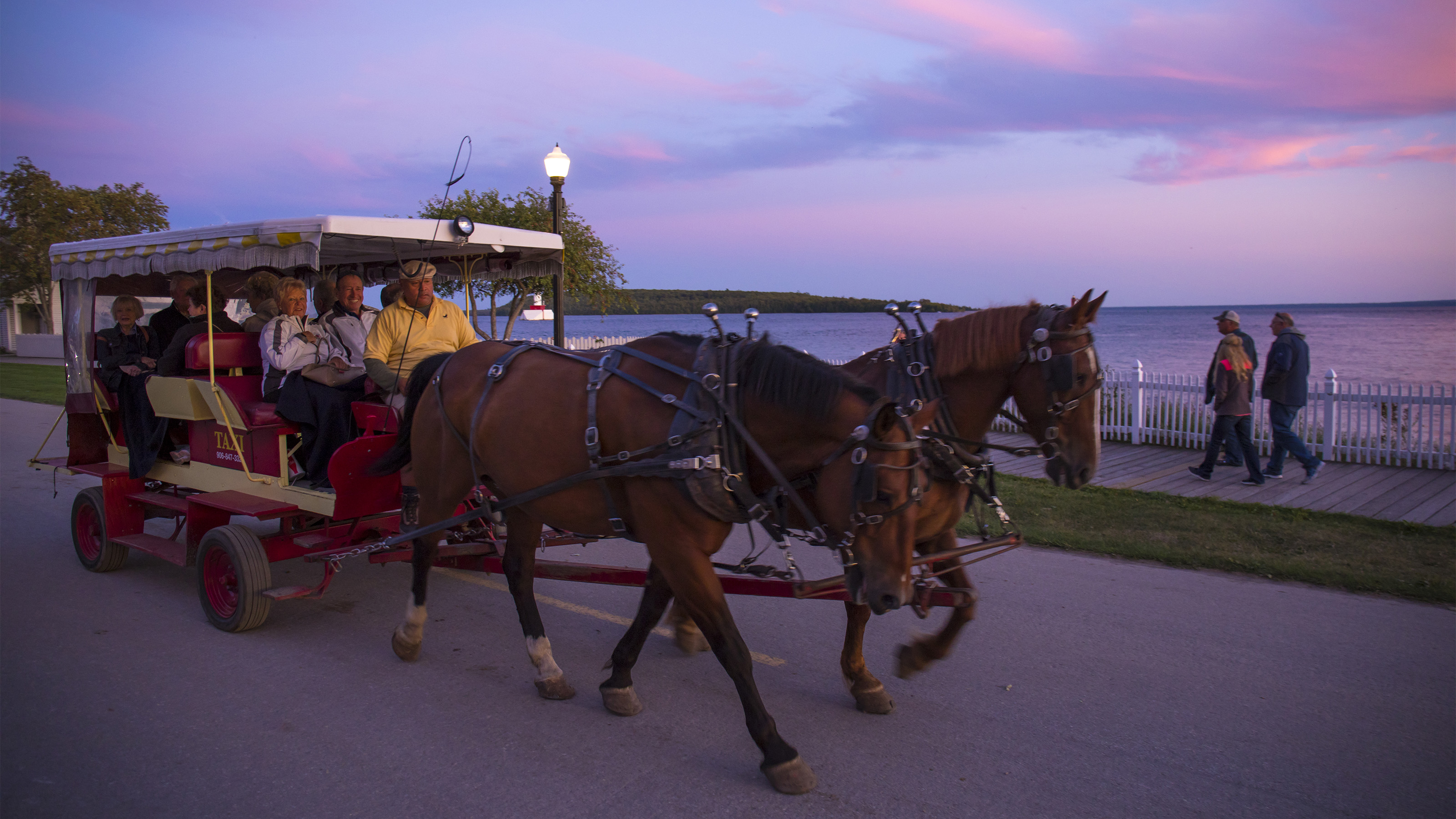 Riders take a waterfront tour on their taxi ride. Photo courtesy of the Mackinac Island Tourism Bureau