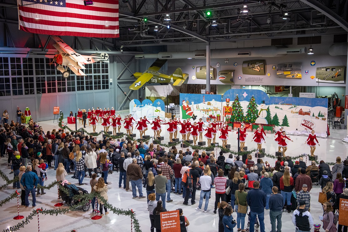 Dancers performing at the EAA Aviation Museum drew sizable crowds. Even the Grinch and his faithful dog Max stop to watch.  Photo by Connor Madison.