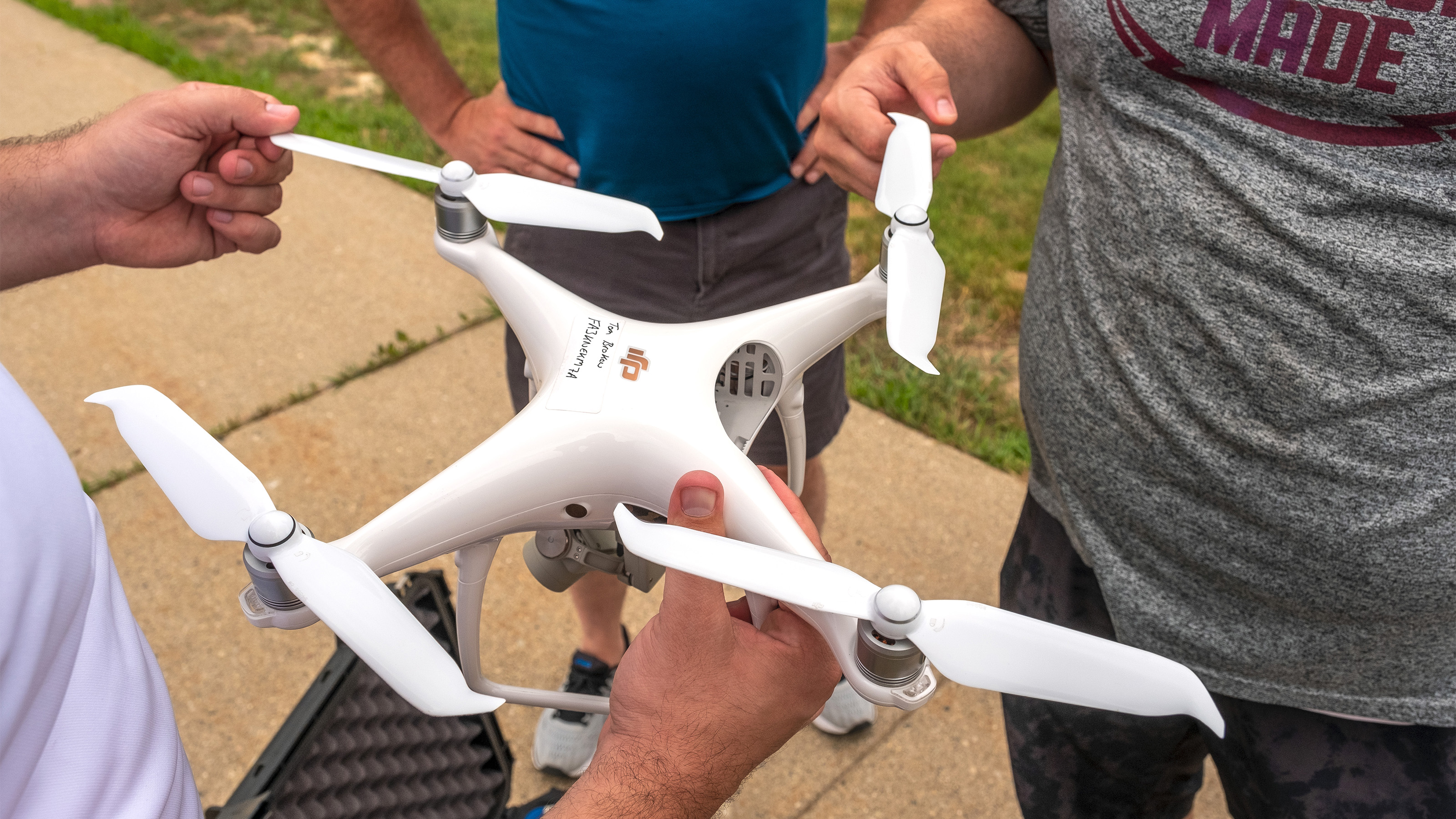 Students check over the propellers on a Phantom 4 pro during their preflight procedures.