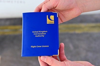 Travis Ludlow displays a U.K. pilot certificate but he also carries a U.S. pilot certificate containing certain stipulations. Ludlow earned a glider pilot certificate in the United Kingdom at age 14. Photo by David Tulis.                                          