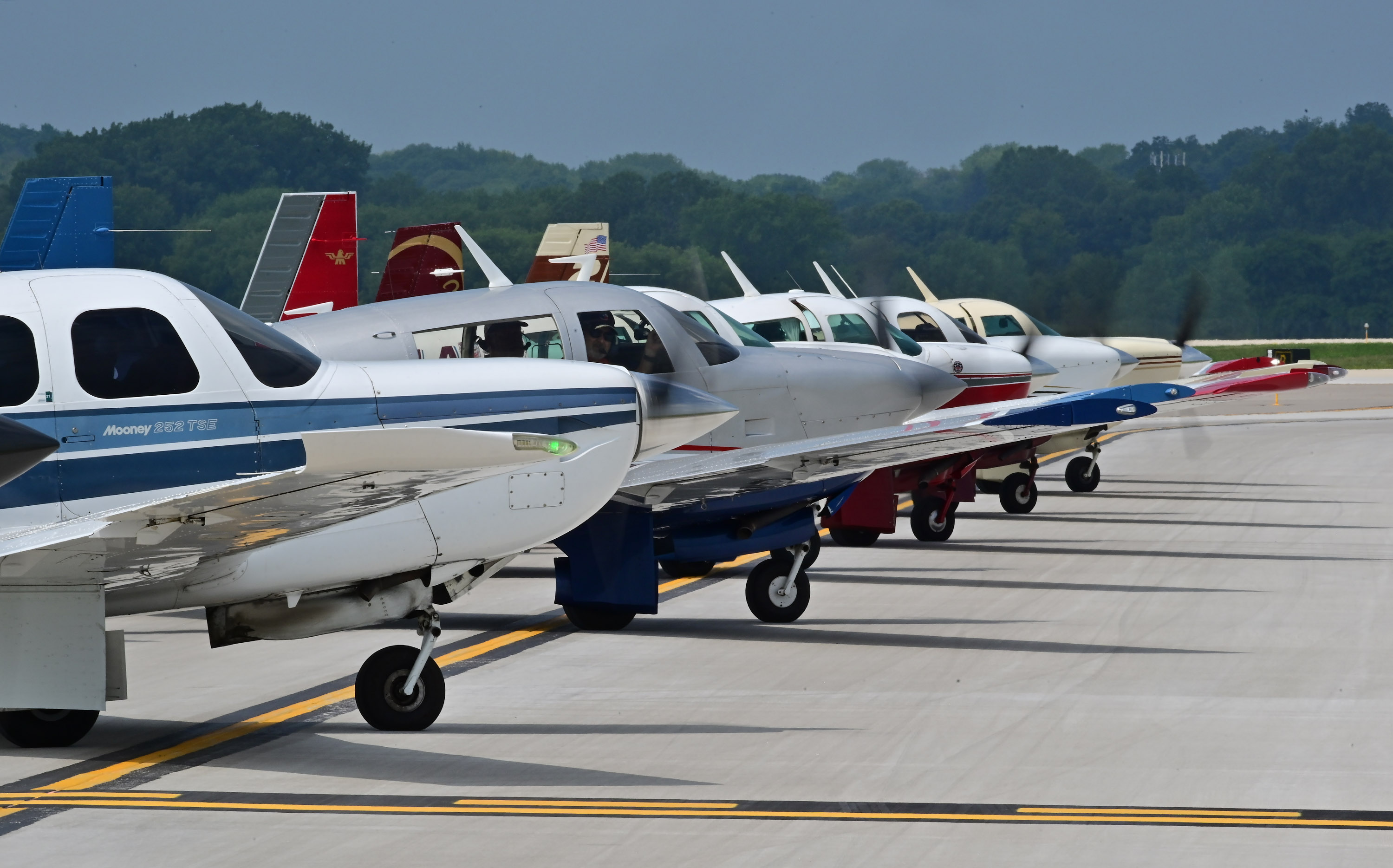 Mooney Caravan pilots line up to practice formation techniques at Dane County Regional Airport-Truax Field in Madison, Wisconsin, about 70 miles away from Wittman Regional Airport before flying to EAA AirVenture in Oshkosh, Wisconsin. Photo by David Tulis.