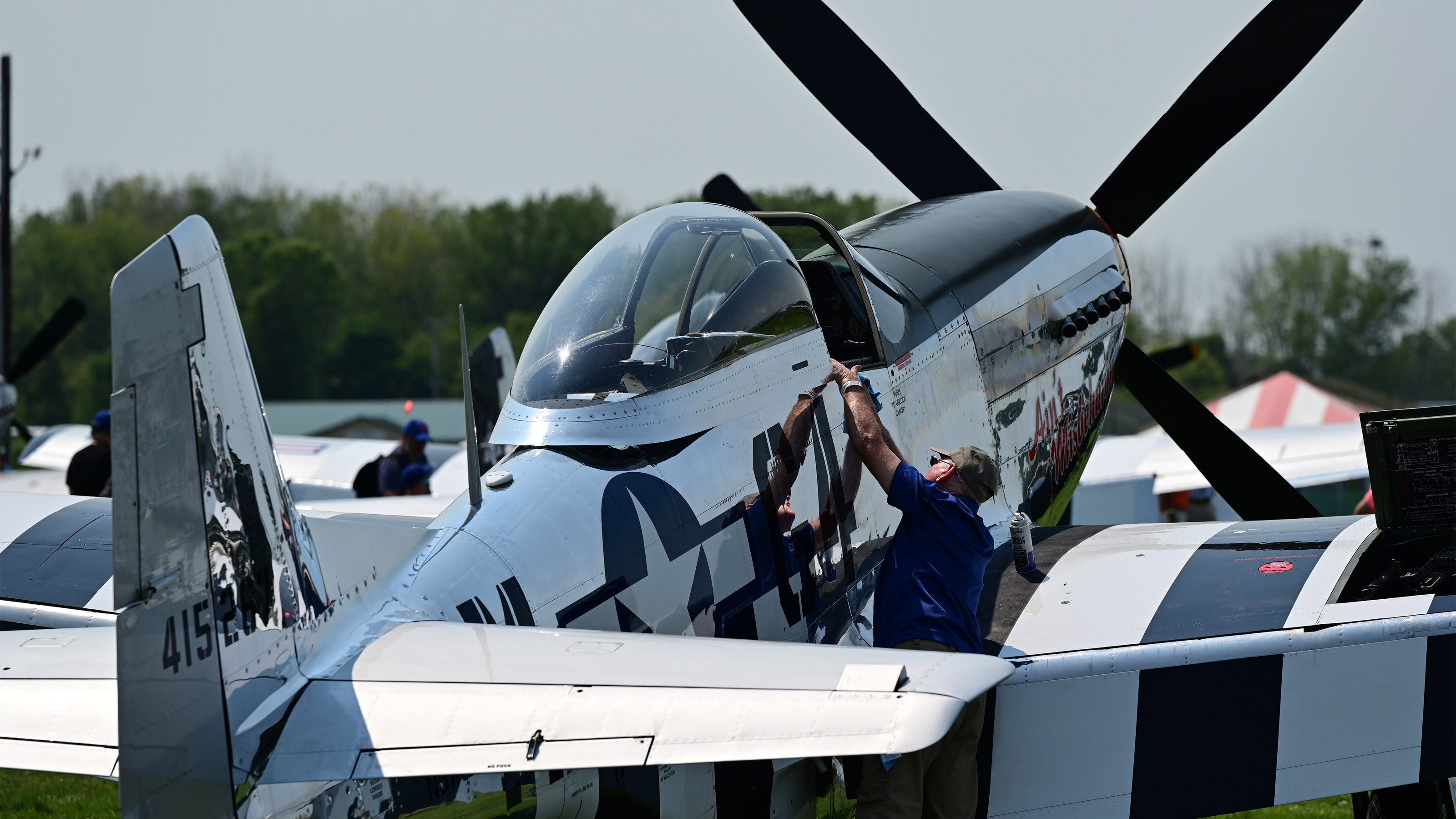 A crewman polishes a North American P-51 Mustang in the wardbirds area during EAA AirVenture July 27. Photo by David Tulis.